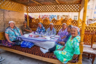 Women in traditional traditional costume at a typical Uzbek table