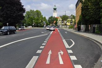 Red cycle path between the car lanes