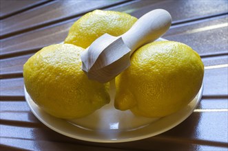 Three yellow lemons on a plate