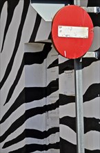 Sign with No trespassing in front of wall with zebra pattern