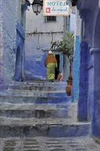 Woman walking up stairs in blue city