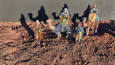 Nativity figures with camels cast shadows on a wall