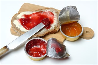 Slice of bread with jam and jam in portion pack