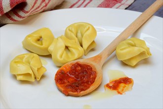 Pasta and cooking spoon with tomato sauce on plate