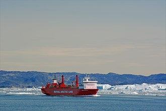 Royal Arctic Line supply vessel in front of icebergs