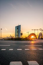 View through a roundabout with bridge and sunset to the ECB and the Frankfurt skyline