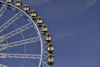 Gondolas from the Ferris wheel against a blue sky