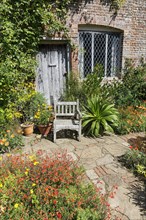 Cottage with garden chair in flowering front garden
