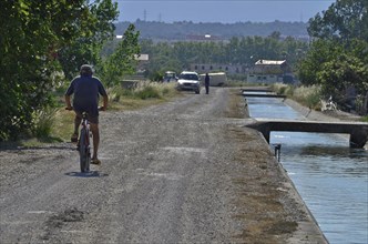 Cyclists at the canal in the Ebro Delta