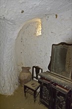 Old dressing table with mirror and chair in cave house