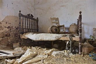 Wicker bottles with chair on bed of abandoned house
