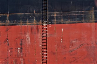 Rope ladder on the red and black side of a freighter