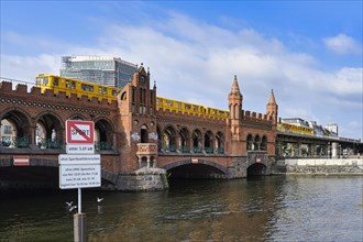Yellow S-Bahn on Oberbaum bridge over the Spree river