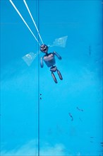 Figure as parachutist at blue metal door