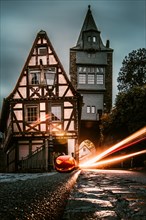 Long exposure with light pullers and halloween in front of a half-timbered house and the town gate