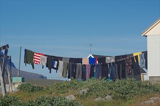 Laundry hanging to dry in front of simple wooden houses