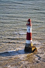 Red and white lighthouse in the sea