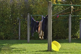 Laundry hung on line with yellow bowl in sunny garden