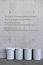 Grey dustbin in front of grey concrete wall with inscription Bayerische Staatsgemaeldesammlung