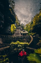 Old gasworks made of solid stone with stone steps in the middle of a gorge with forest and trees. Hrensko Czech Republic