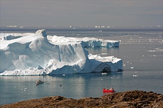 View of red boat in front of huge icebergs
