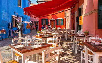 Restaurant with outdoor area in front of the colourful apartment buildings in Burano