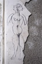 Naked woman as a stick figure on a peeling wall