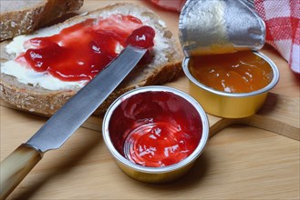 Slice of bread with jam and jam in portion pack