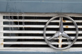 Mercedes star on radiator grille of truck with icicles