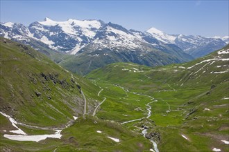 View of alpine panorama above Baumgremnze with mountain meadows below pass road Col de l'Iseran