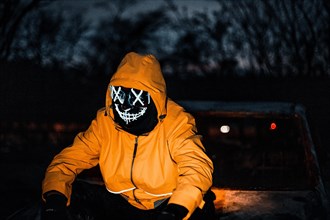 Man with Purge mask on a car wreck