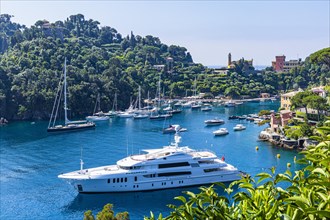 Luxury yacht anchored in the harbour of Portofino behind the church of San Giorgio