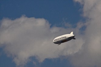 Zeppelin with inscription Sueddeutsche Zeitung in the sky with clouds