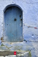 Blue wooden door with red plastic cup