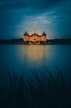 Illuminated Moritzburg Castle at dusk