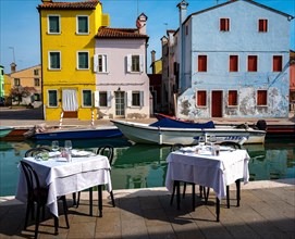 Restaurant with outdoor area in front of the colourful apartment buildings in Burano