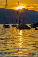 Sailboats at sunrise anchored in the bay of Portofino