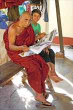 Monk reading newspaper