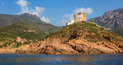 Genoese tower near the village of Girolata with staircase houses in the nature reserve of Scandola