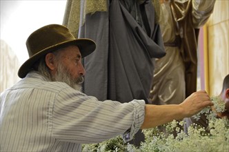 Old man with hat decorates altar in church for Easter