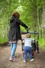 Woman with grandchild walking in the forest