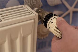 Hand turns a thermostat