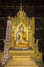 Buddha statue in teakwood monastery