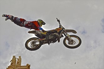 Motorbike performer dismounting in the air in the old town of Lorca