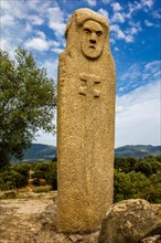 Menhir statue with carved face long sword and dagger