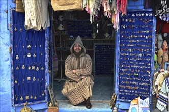 Man sitting in front of his shop with jewellery