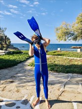 Young man in blue wetsuit diving goggles and snorkel