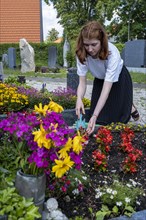 Young woman tending to a grave