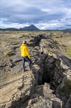 Woman standing at continental rift between North American and Eurasian Plates