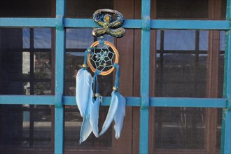 Andalusian Lucky Charm Indalo and Dreamcatcher on Iron Grille of Window
